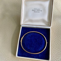 A solid gold hinged bangle made in 1978 in Sävsjö, Sweden. Solid bangles like this are rare finds! What I love about them is that they cannot dent - this style is a solid bar of gold! This amazing vintage Scandinavian 18k gold bangle is oval shaped with a femme half-round cross section. Interior of the oval measures 2 inches (50mm) x 2.4 inches (60mm) and opens with a well working and beautiful hinge. She weighs an excellent 18.2g
