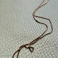 Gold chain necklace on a textured light blue surface