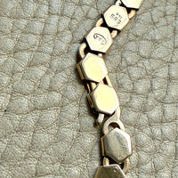 vintage 14k gold Necklace with hexagonal link on a textured beige surface