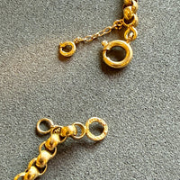 Close-up of a gold chain on a gray surface