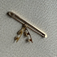 14k Gold brooch on a textured gray surface