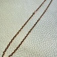 Gold chain on a textured light gray background