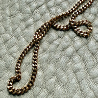 Gold chain on a textured light gray surface