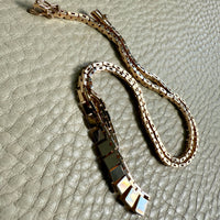 gold chain with a clasp on a textured surface