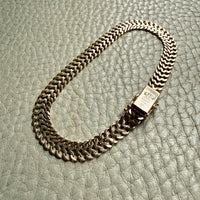 gold chain bracelet on a textured gray surface