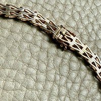 gold necklace detail on a textured gray surface