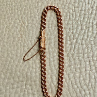 18k Rose gold chain bracelet on a textured beige surface PenelopePenelope.com
