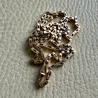 14k Gold vintage chain necklace on a textured gray background