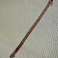 18 Gold link bracelet on a textured gray surface