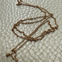vintage 18k gold chain necklace on a textured light gray surface