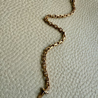 A vintage 18k gold biker link bracelet with a secure clasp, laid out on a textured background.