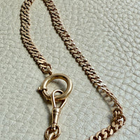 antique Gold chain necklace on a textured light gry background