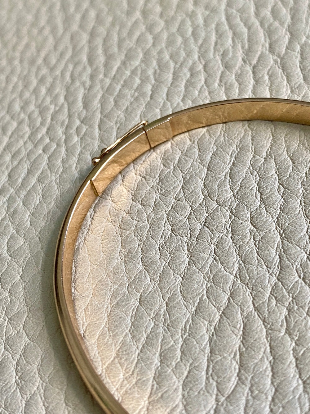 A solid gold hinged bangle made in 1978 in Sävsjö, Sweden. Solid bangles like this are rare finds! What I love about them is that they cannot dent - this style is a solid bar of gold!  This amazing vintage Scandinavian 18k gold bangle is oval shaped with a femme half-round cross section. Interior of the oval measures 2 inches (50mm) x 2.4 inches (60mm) and opens with a well working and beautiful hinge. She weighs an excellent 18.2g