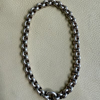 Silver chain necklace on a light gray background