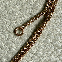 Gold chain on a textured light gray background