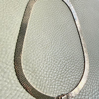 14k gold vintage cleopatra necklace on a textured light gray background