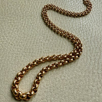 18k Gold vintage graduated rolo chain necklace on a textured beige surface penelopepenelope.com