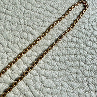 Gold chain on a light gray textured surface
