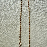 Gold chain on a textured light gray background