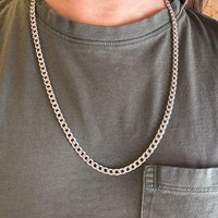vintage 14k white gold chain necklace on a person wearing a green shirt.