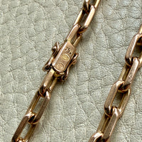 Close-up of a gold chain on a textured light green background