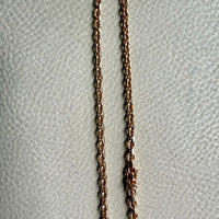 gold chain on a textured light gray background