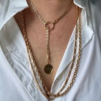 Gold chain necklaces on a white shirt