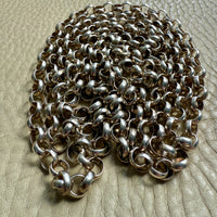 Silver chain on a textured beige surface