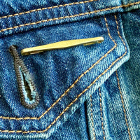 vintage 18k Gold brooch on a blue denim background