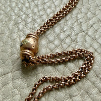 gold chain necklace on a textured light gray surface