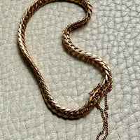 18k vintage Gold curb chain bracelet on a textured light gray surface penelopepenelope.com