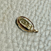 Gold pendant on a textured beige background