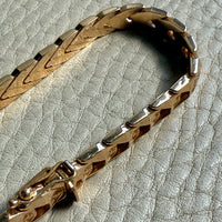 18 Gold link bracelet on a textured gray surface