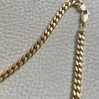 Gold chain clasp detail on a textured gray surface