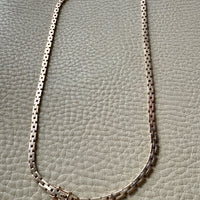 14k Gold vintage chain necklace on a textured gray background