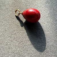 red purpurin egg pendant on gray background