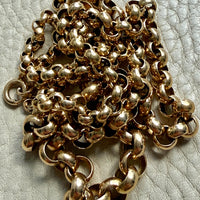 Gold chain on a textured light gray surface