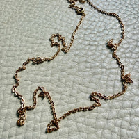 Gold chain necklace on a textured light blue surface