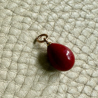 red purpurin egg pendant on gray background