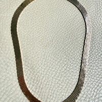 14k gold vintage cleopatra necklace on a textured light gray background