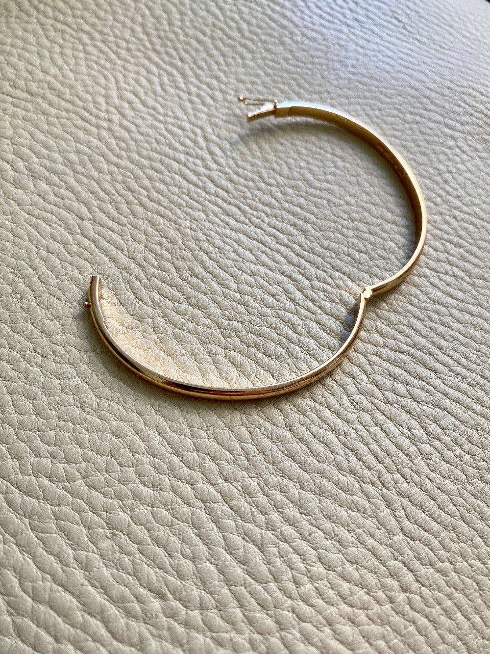 A solid gold hinged bangle made in 1978 in Sävsjö, Sweden. Solid bangles like this are rare finds! What I love about them is that they cannot dent - this style is a solid bar of gold!  This amazing vintage Scandinavian 18k gold bangle is oval shaped with a femme half-round cross section. Interior of the oval measures 2 inches (50mm) x 2.4 inches (60mm) and opens with a well working and beautiful hinge. She weighs an excellent 18.2g