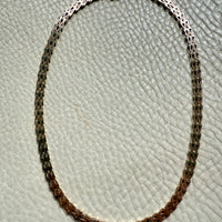 gold chain necklace on a textured gray surface