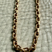 vintage 18k yellow gold biker link chain necklace on a textured light gray surface