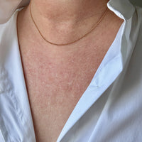18k gold rolo Necklace on a person wearing a white shirt