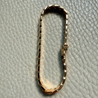 18 Gold link bracelet on a textured gray surface