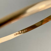 A solid gold hinged bangle made in 1978 in Sävsjö, Sweden. Solid bangles like this are rare finds! What I love about them is that they cannot dent - this style is a solid bar of gold! This amazing vintage Scandinavian 18k gold bangle is oval shaped with a femme half-round cross section. Interior of the oval measures 2 inches (50mm) x 2.4 inches (60mm) and opens with a well working and beautiful hinge. She weighs an excellent 18.2g