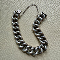 Silver chain bracelet on a textured beige surface