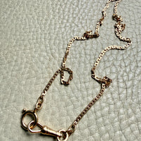 18k Gold virola link chain on a textured light gray surface