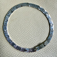 vintage silver necklace on a textured beige surface