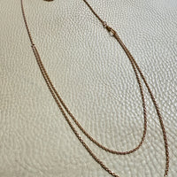 antique 18k gold chain necklace on a textured beige surface. Penelope Penelope vintage 18k gold fine jewelry